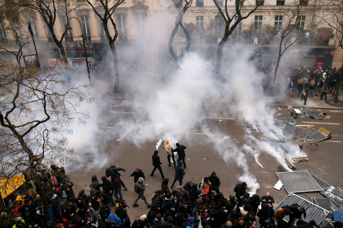 Protesters throw tear gas canisters back amid clashes during a demonstration as part of the ninth day of nationwide strikes and protests against French government's pension reform, in Paris, France, on 23rd March, 2023.  