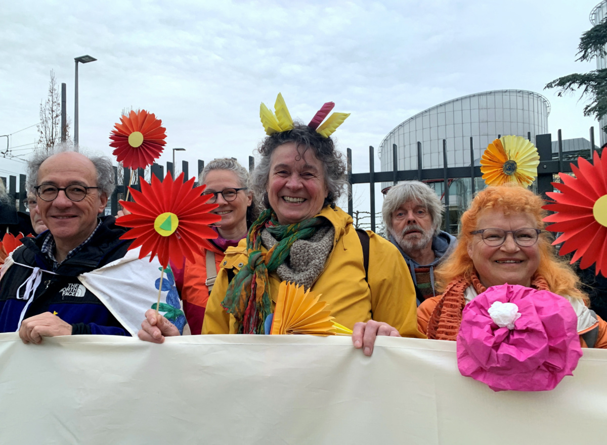 Supporters of the Senior Women for Climate Protection association hold paper flowers and a banner outside the European Court of Human Rights in Strasbourg, France, on 29th March, 2023.