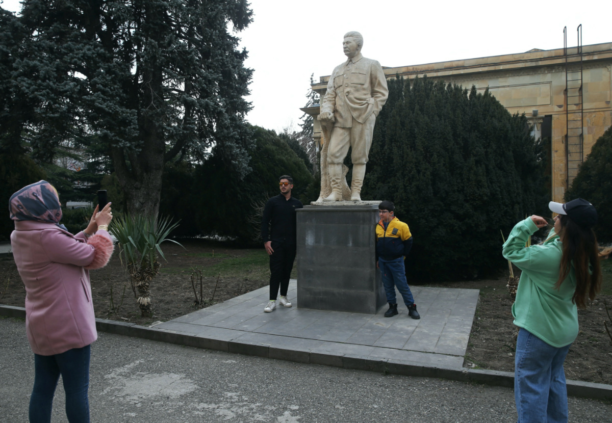 People take pictures next to a monument to Soviet leader Joseph Stalin at a museum in his hometown of Gori, Georgia March 1, 2023. REUTERS/Irakli Gedenidze
