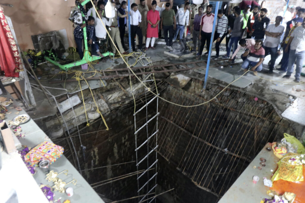 People stand around a structure built over an old temple well that collapsed Thursday as a large crowd of devotees gathered for the Ram Navami Hindu festival in Indore, India, on Thursday, 30th March 2023