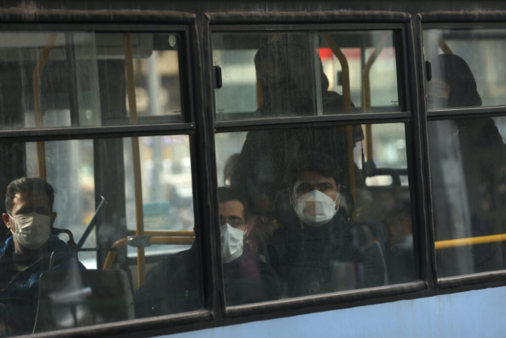 An Iranian man wears a protective mask as he sits in a bus following the increase in air pollution in Tehran, Iran, November 24, 2021. Majid Asgaripour/WANA