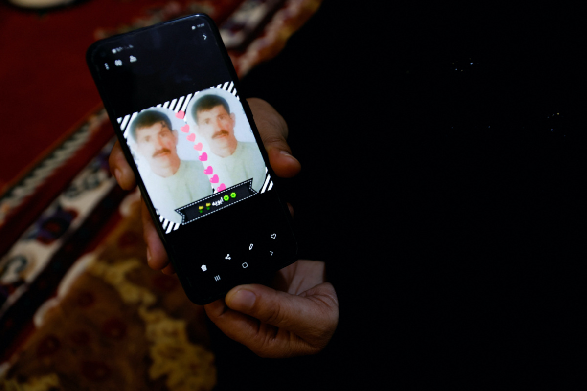 Ikhlas Talal, 43, shows a picture of her husband on the phone, who went missing as their area was liberated from Islamic State in 2016, in Saqlawiya, Iraq, February 2, 2023. 