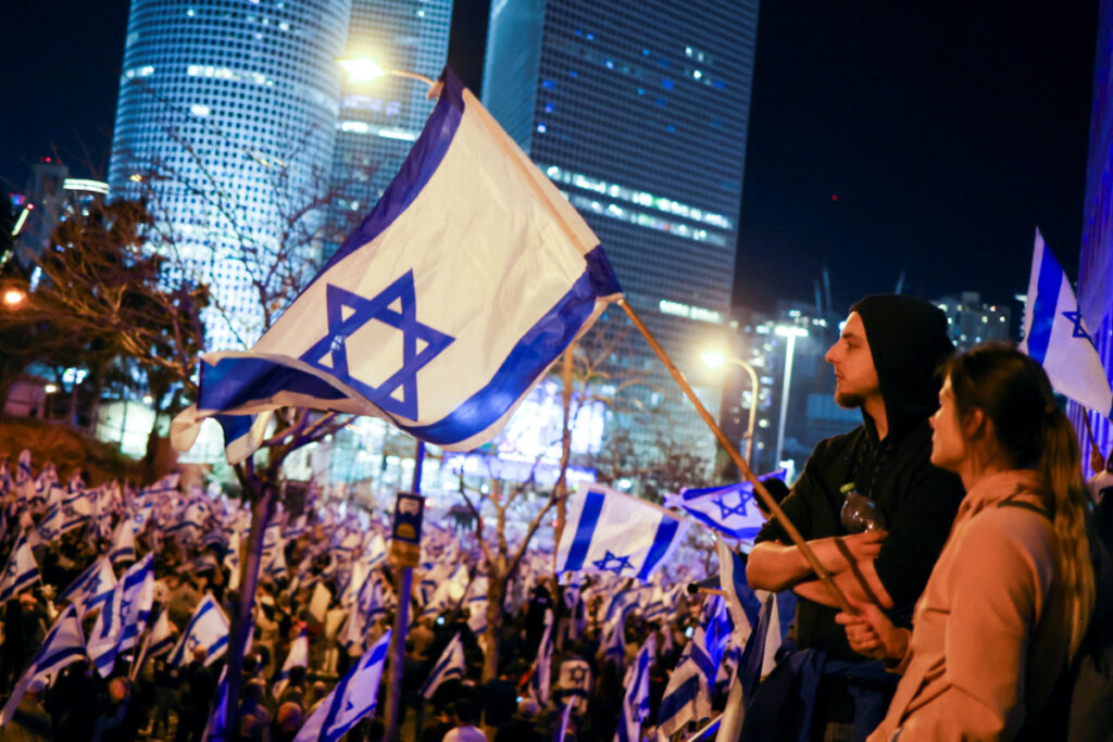People hold Israeli flags during a demonstration as Israeli Prime Minister Benjamin Netanyahu's nationalist coalition government presses on with its contentious judicial overhaul, in Tel Aviv, Israel, March 11, 2023.
