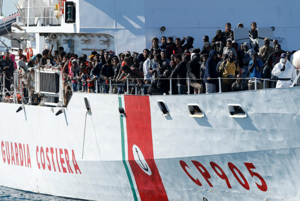 FILE PHOTO: Migrants arrive by the Italian coastguard vessel Peluso in the Sicilian harbour of Augusta, Italy, May 13, 2016. REUTERS/Antonio Parrinello/File Photo