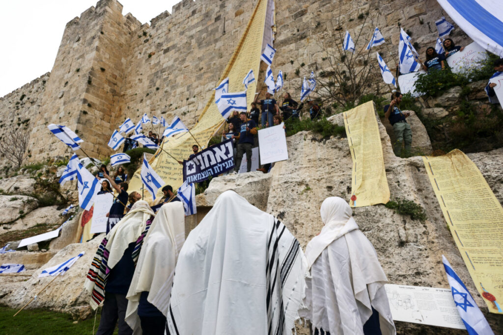 Demonstrators drape the national flag of Israel and copies of the Israeli Declaration of Independence on the walls of Jerusalem's Old City in an act of protest as Israeli Prime Minister Benjamin Netanyahu's nationalist coalition government presses on with its contentious judicial overhaul, in Jerusalem, March 23, 2023. REUTERS/Ronen Zvulun