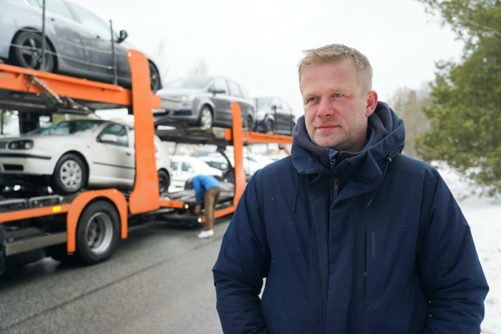 Reinis Poznaks, founder of the NGO known as Twitter Convoy stands in front of a trailer loaded with vehicles, which were confiscated from drunk drivers, in Riga, Latvia, March 8, 2023. REUTERS/Janis Laizans