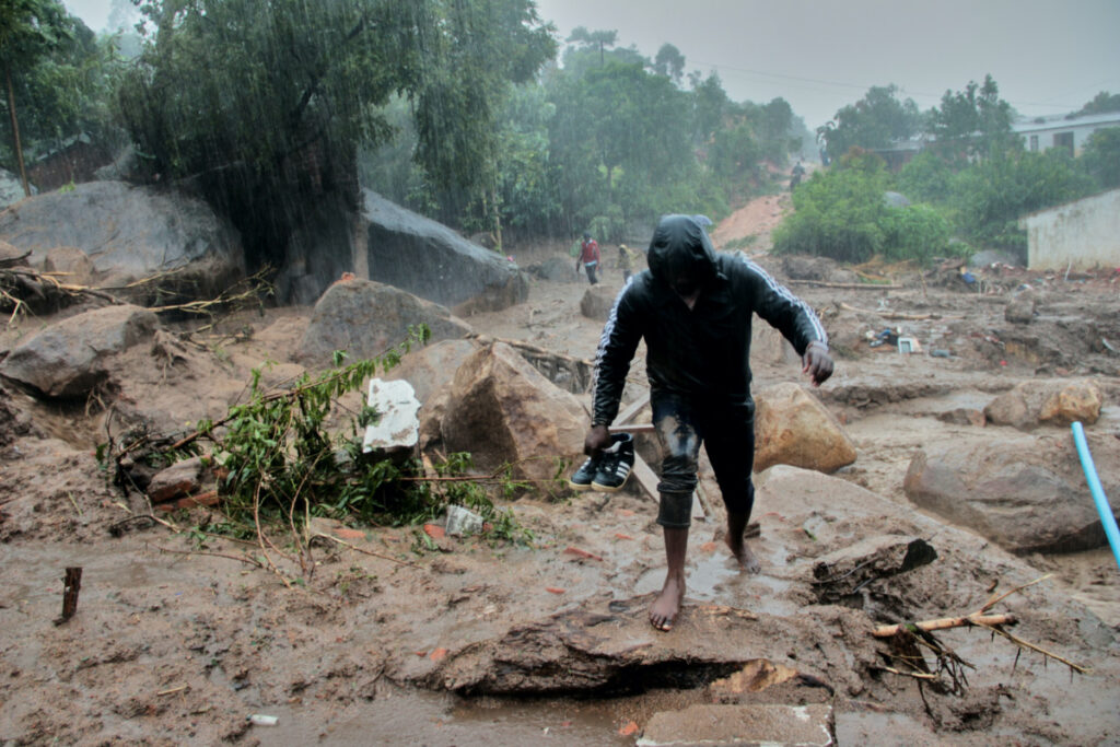 A man walks away from buildings damaged by Cyclone Freddy in Chilobwe, Blantyre, Malawi, March 13, 2023.