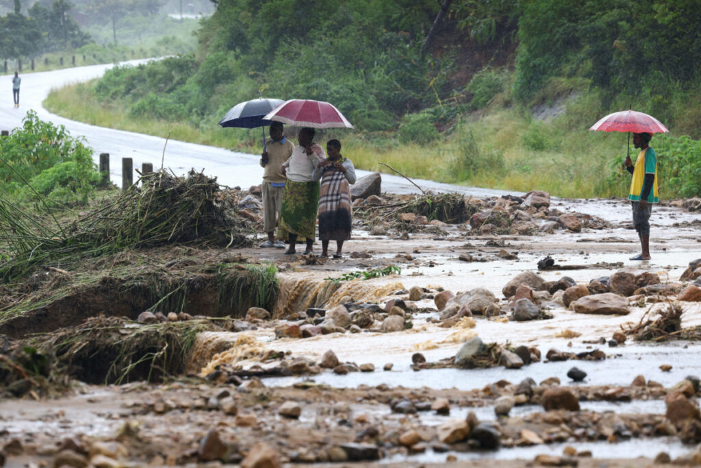 Locals in the Chiradzulu district look at the damage on a road after mudslides and rockfalls in the area caused by the aftermath of Cyclone Freddy in Blantyre, Malawi, March 15, 2023