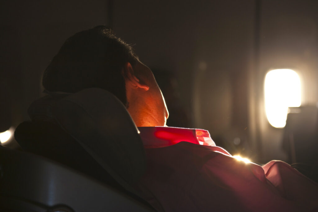 man sleeping in the seat of an aircraft in sunrise
