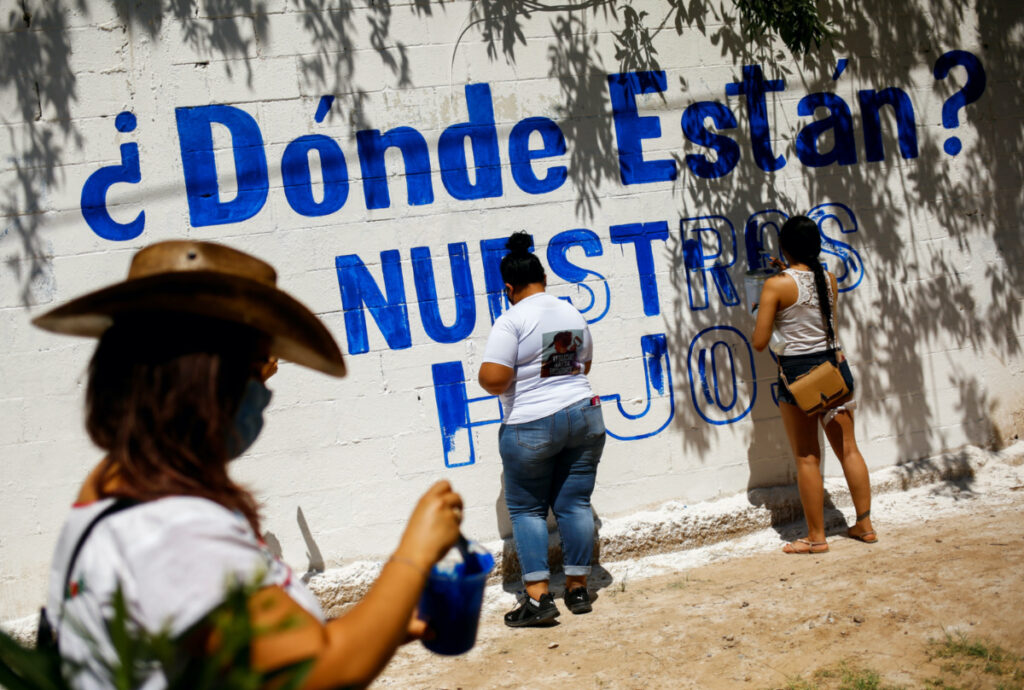 Relatives of missing persons and activists paint a mural