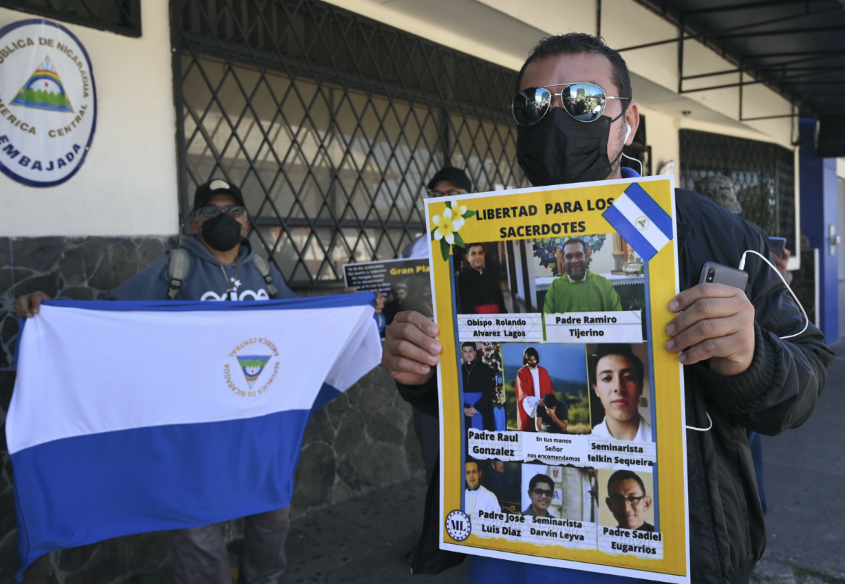 A Western Democratic Movement activist holds a poster with a message that reads in Spanish; “Free the priests,” and images of clergy imprisoned by the government of Daniel Ortega, including Bishop Rolando Alvarez of Matagalpa, during a protest outside the Nicaraguan embassy, in San Jose, Costa Rica, Monday, Feb. 20, 2023