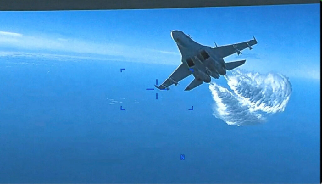 A Russian Su-27 aircraft dumps fuel while flying upon a U.S. Air Force intelligence, surveillance, and reconnaissance unmanned MQ-9 aircraft over the Black Sea, March 14, 2023 in this still image taken from a handout video. Courtesy of U.S. Air Force/Handout via REUTERS