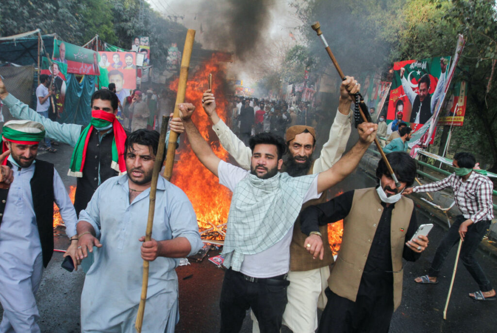 Supporters of former Pakistani Prime Minister Imran Khan, react as they blocked the road during clashes, ahead of Khan's possible arrest outside his home, in Lahore, Pakistan March 14, 2023.