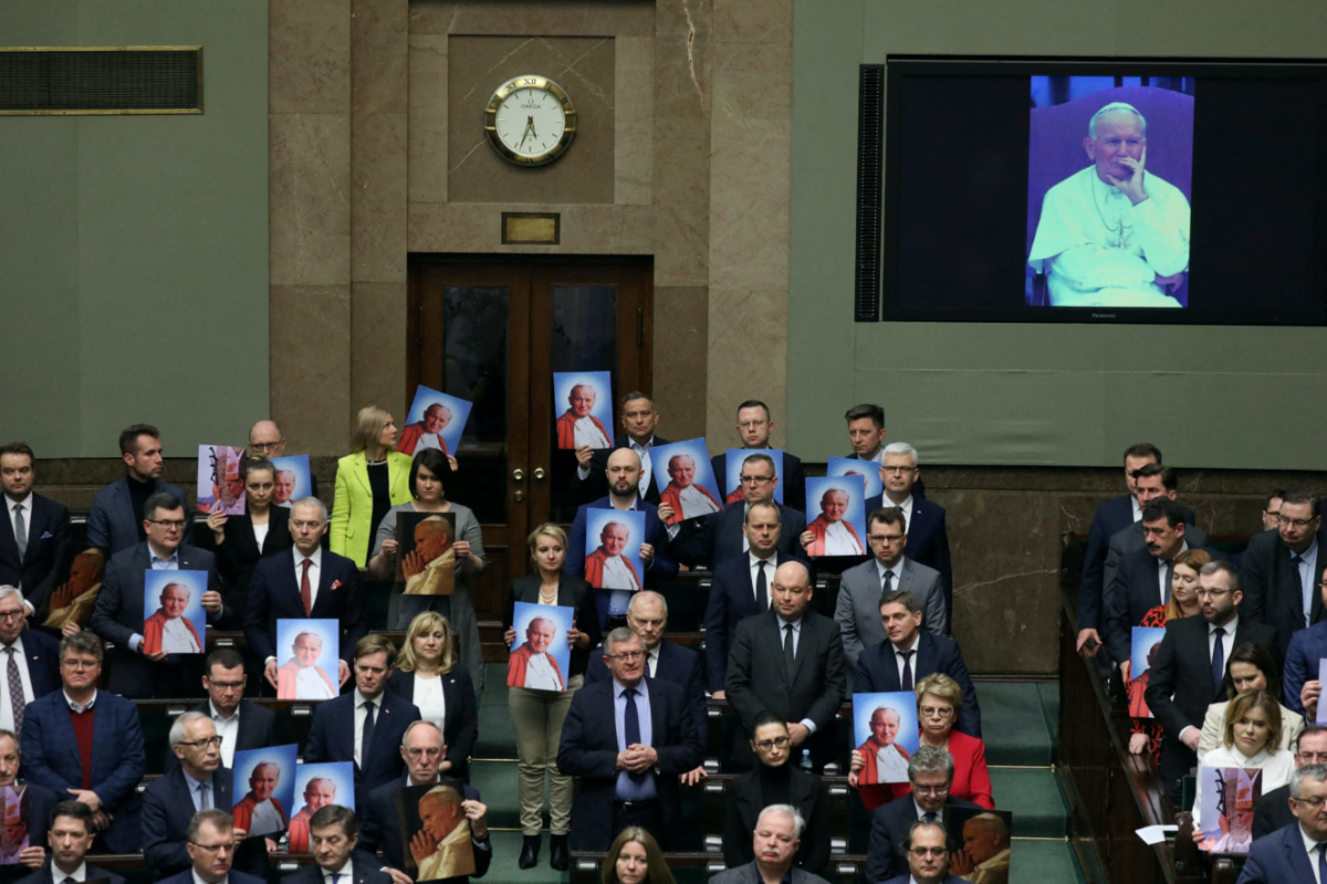 Law and Justice law makers hold images of Pope John Paul II during debate about resolution on defending the name of John Paul II, at parliament in Warsaw, Poland, March 9, 2023. Slawomir Kaminski/Agencja Wyborcza.pl via REUTERS/File Photo