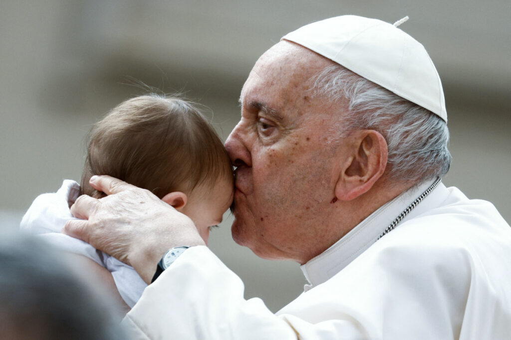 Pope Francis kisses a child during the weekly general audience in St. Peter's Square at the Vatican, March 8, 2023.