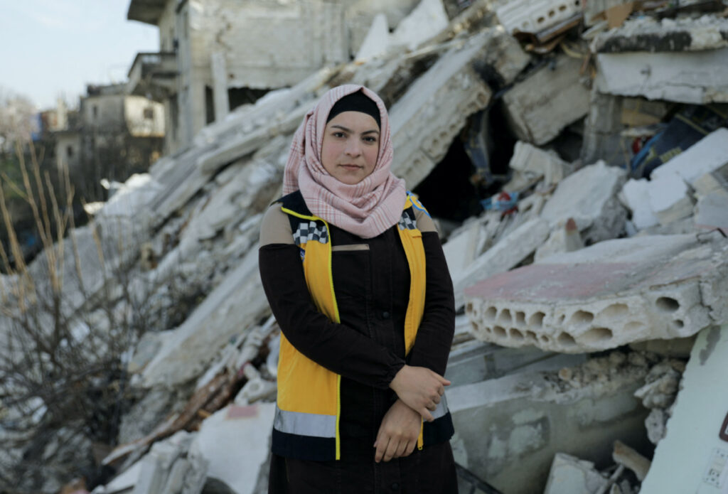 Salam Mahmoud, a volunteer at the Syria Civil Defence, poses for a picture on the rubble of a building that was damaged by last month's devastating earthquake, in rebel-held al-Maland village, in Idlib province, Syria March 5, 2023.