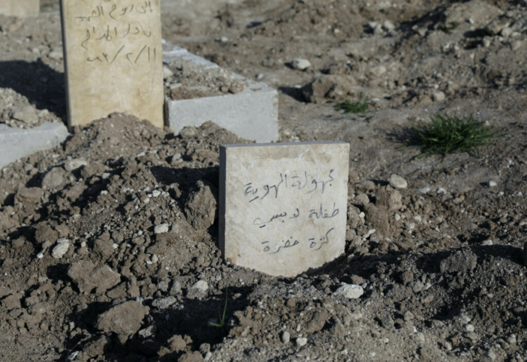 A view shows a gravestone reading "unidentified, little girl wearing green sweater" in Arabic inside a cemetery in the rebel-held town of Jandaris, Syria March 4, 2023. REUTERS/Khalil Ashawi