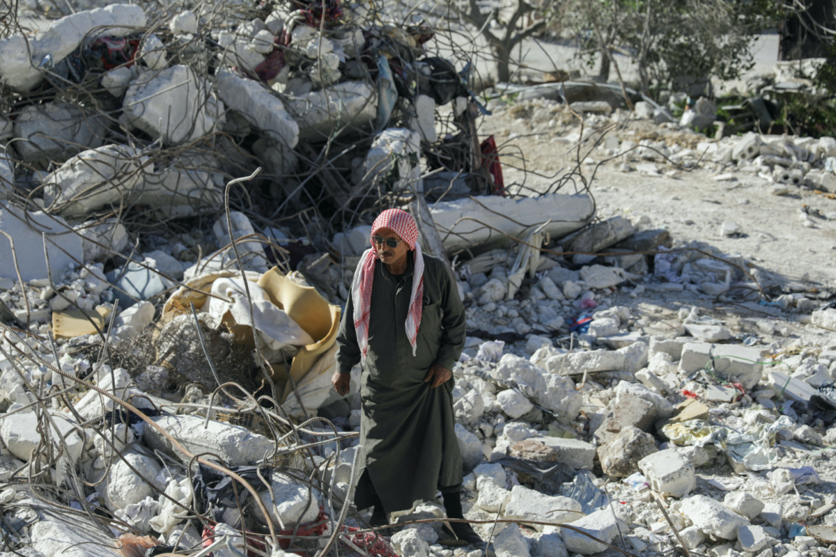 Fadel El Jaber, stands on rubble of the building his son lived with his family, that collapsed from last month's deadly earthquake in the town of Salqin, Syria, on 10th March, 2023. 