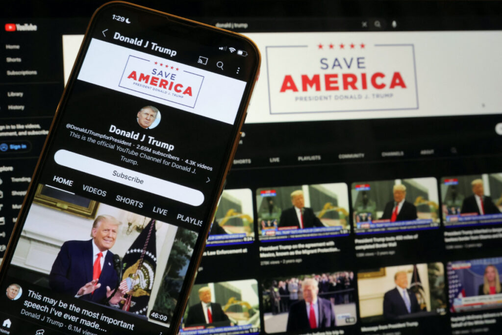 Former U.S. President Donald Trump's YouTube account is seen on a mobile phone and laptop computer after being restored by Google and its parent company Alphabet Inc, as Google lifted a more than two-year suspension imposed on Trump after the deadly January 6, 2021 Capitol Hill riot, in Washington, U.S. March 17, 2023. REUTERS/Jim Bourg