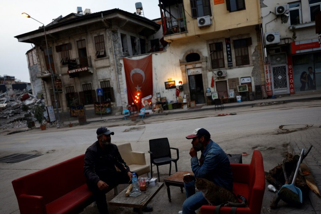 Mehmet Serkan Sincan, owner of an antique shop in central Antakya, and his friend Ben Hur Side hang out outside Sincan's damaged store in the aftermath of a deadly earthquake, in Antakya, Hatay province, Turkey, March 2, 2023. REUTERS/Susana Vera