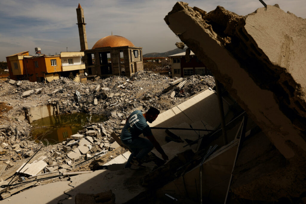 Ibrahim Kurt helps salvage belongings from a collapsed home in the aftermath of a deadly earthquake in Nurdagi, Turkey, March 5, 2023. REUTERS/Susana Vera