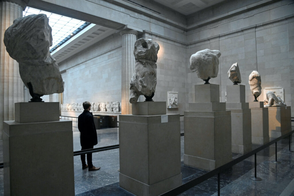 FILE PHOTO: An employee poses as he views examples of the Parthenon sculptures, sometimes referred to in the UK as the Elgin Marbles, on display at the British Museum in London, Britain, January 25, 2023. REUTERS/Toby Melville/File Photo