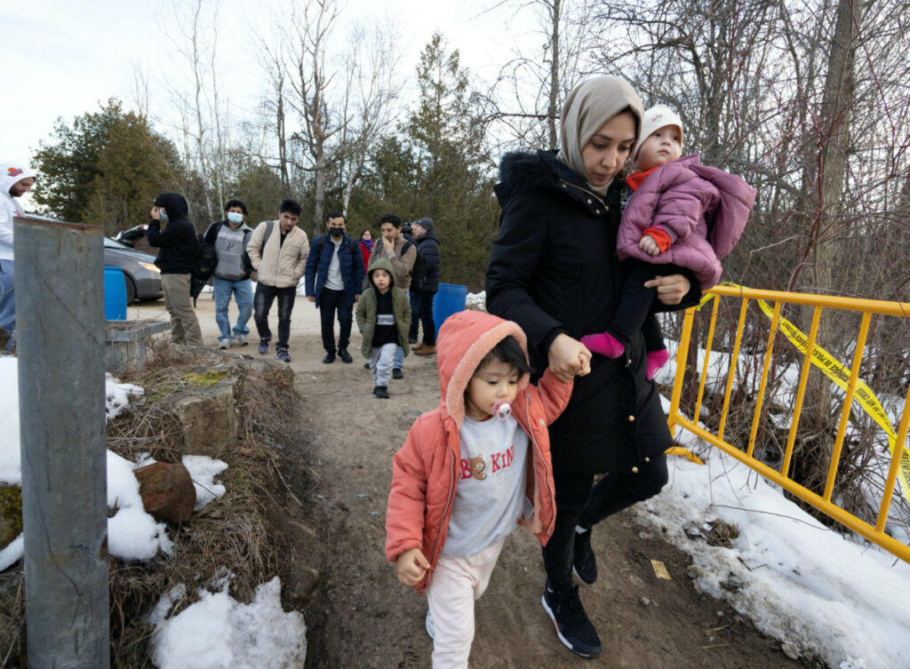 Asylum seekers that stated they were from Afghanistan cross into Canada at Roxham Road, an unofficial crossing point from New York State to Quebec in Champlain, New York, US, on 24th March, 2023.