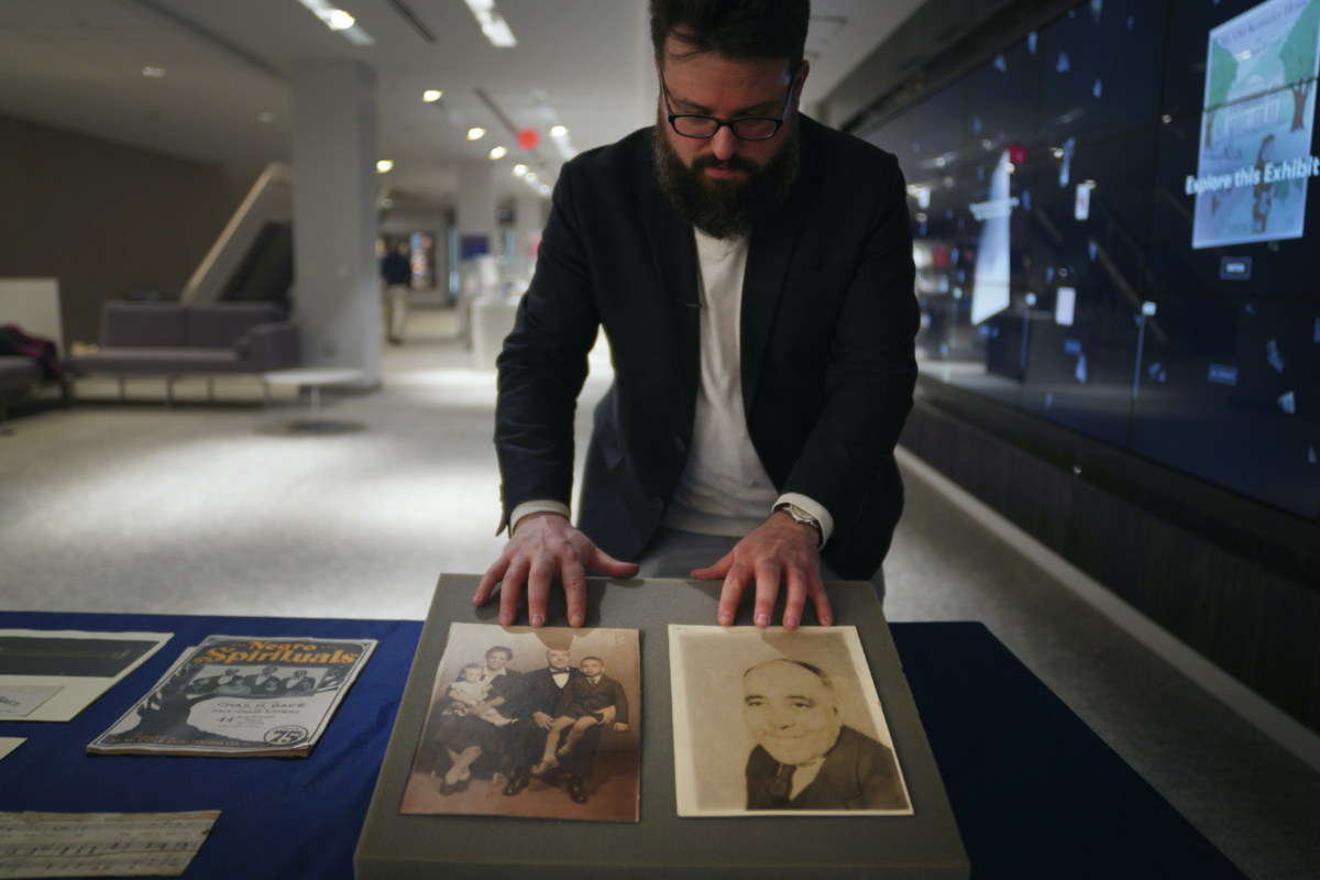 Christopher Lynch, music historian and project coordinator with the Center for American Music at the University of Pittsburgh, adjusts a set of photos of gospel musician, composer and publisher Charles Henry Pace and his family, on Tuesday, 28th February, 2023, at the University of Pittsburgh, in Pittsburgh. 