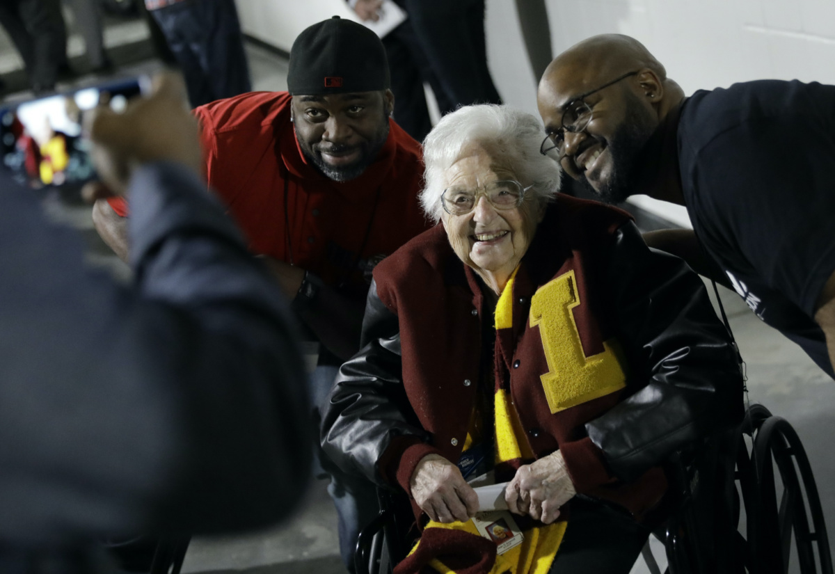 Loyola-Chicago basketball chaplain Sister Jean Dolores Schmidt, poses with fans for a photo before the first half of a regional final NCAA college basketball tournament game, Saturday, March 24, 2018, in Atlanta.