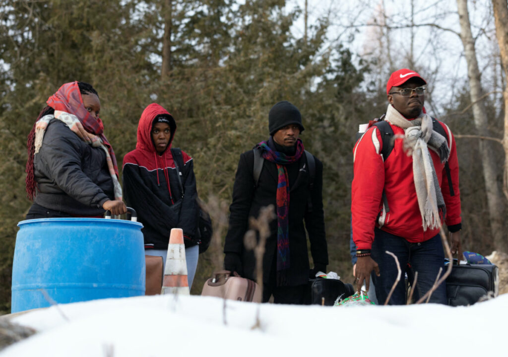 Migrants wait to cross into Canada at Roxham Road, an unofficial crossing point from New York State to Quebec for asylum seekers, in Champlain, New York, U.S. March 25, 2023. REUTERS/Christinne Muschi