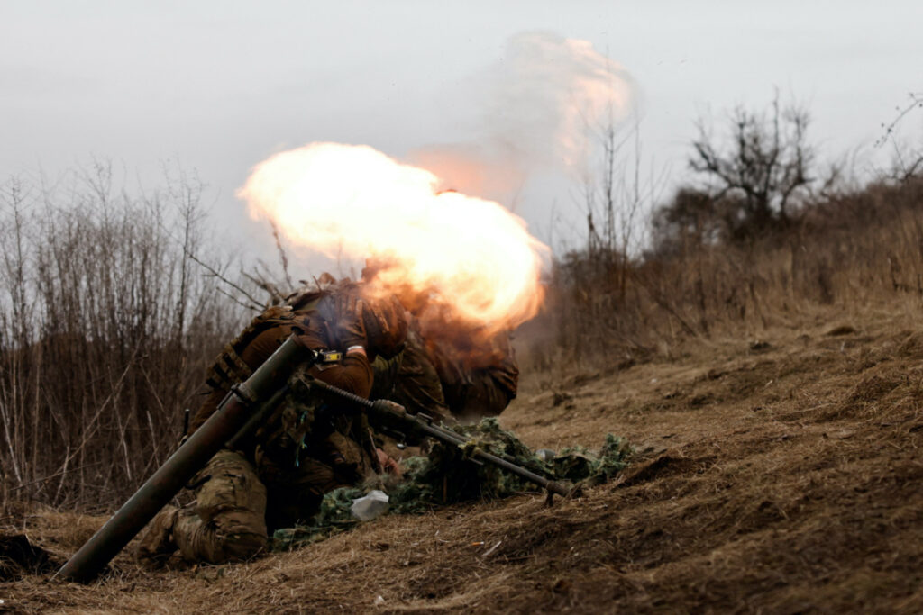 Ukrainian soldiers of the Paratroopers' of 80th brigade take cover as they fire a mortar shell at a frontline position near Bakhmut, amid Russia's attack on Ukraine, in Donetsk region, Ukraine March 16, 2023. REUTERS/Violeta Santos Moura