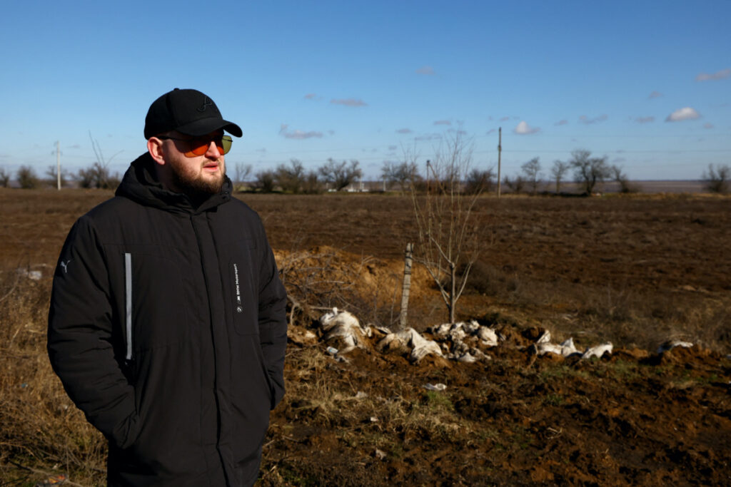 Grain farmer Andrii Povod stands beside his field that has been damaged by shelling and trenches, amid Russia's invasion of Ukraine, in Bilozerka, Kherson region, Ukraine, February 20, 2023. REUTERS/Lisi Niesner