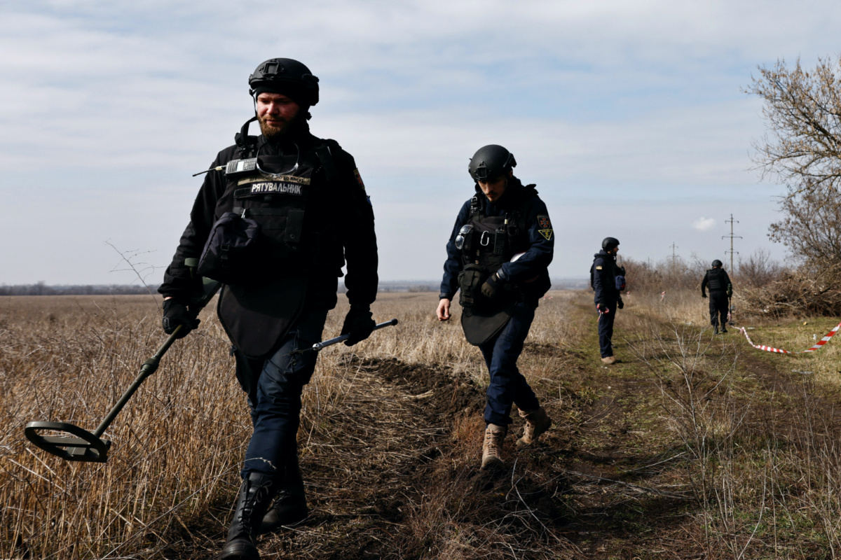 Members of the de-mining department of the Ukrainian Emergency Services survey an area of farmland and electric power lines for land mines and other unexploded ordnance for electricians to access power towers damaged by Russian strikes in order to repair them, amid Russia's invasion of Ukraine, in Korovii Yar, in the Eastern Donetsk region, Ukraine, March 20, 2023. REUTERS/Violeta Santos Moura