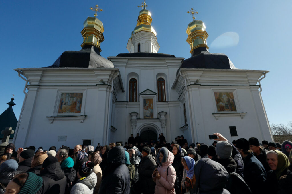 Believers of the Ukrainian Orthodox Church, accused of being linked to Moscow, pray while they block an entrance to a church at a compound of the Kyiv Pechersk Lavra monastery, amid Russia's attack on Ukraine, in Kyiv, Ukraine, on 30th March, 2023.