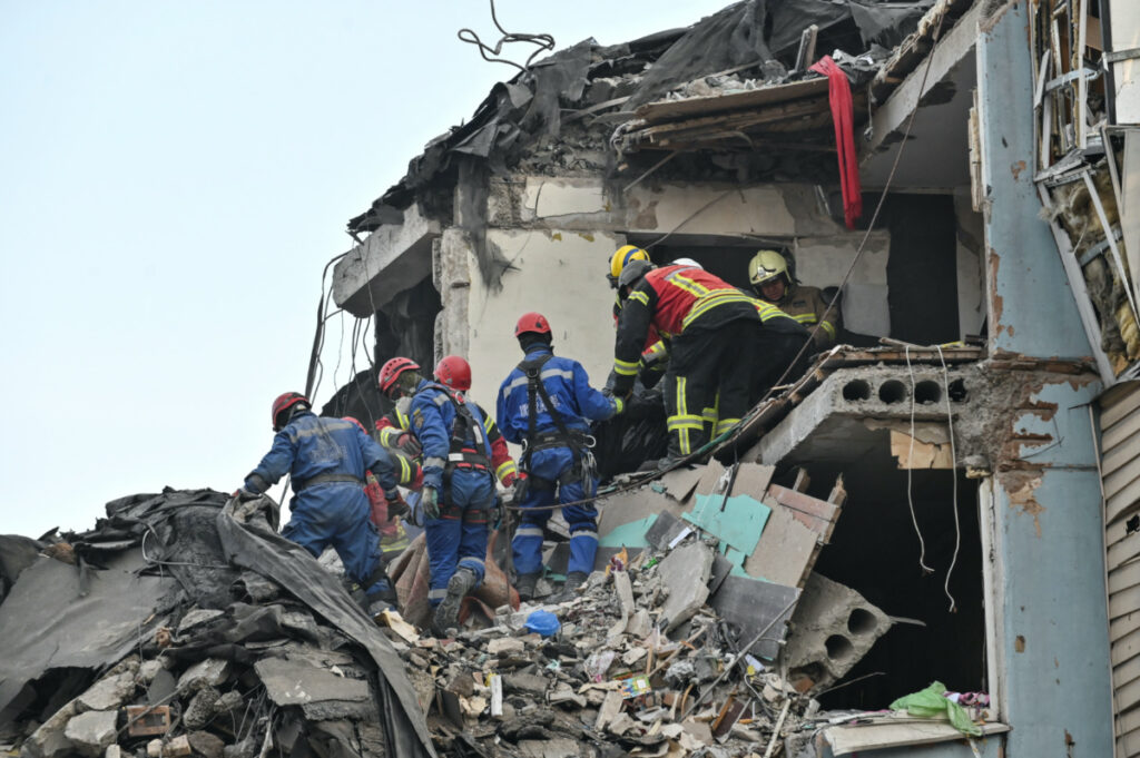 Rescuers carry the body of a person found at a site of a residential building heavily damaged by a recent Russian missile strike, amid Russia's attack on Ukraine, in Zaporizhzhia, Ukraine March 4, 2023.