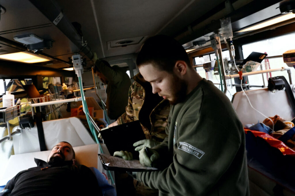 A Ukrainian volunteer medic treats wounded Ukrainian soldiers in a converted bus during an evacuation operation from the eastern frontline near Bakhmut to hospitals in the Dnipropetrovsk region, in Ukraine March 15, 2023. REUTERS/Violeta Santos Moura