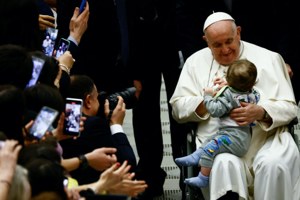 Pope Francis holds a child during a meeting with the faithful of parishes from Rho at the Vatican, March 25, 2023. REUTERS/Yara Nardi