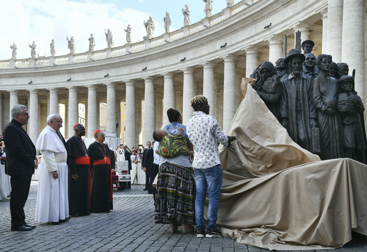 Pope Francis, left, watches the unveiling of a new sculpture on the occasion of the Migrant and Refugee World Day, in St. Peter's Square, at the Vatican, on Sept. 29, 2019. (Vincenzo Pinto/Pool Photo via AP)
