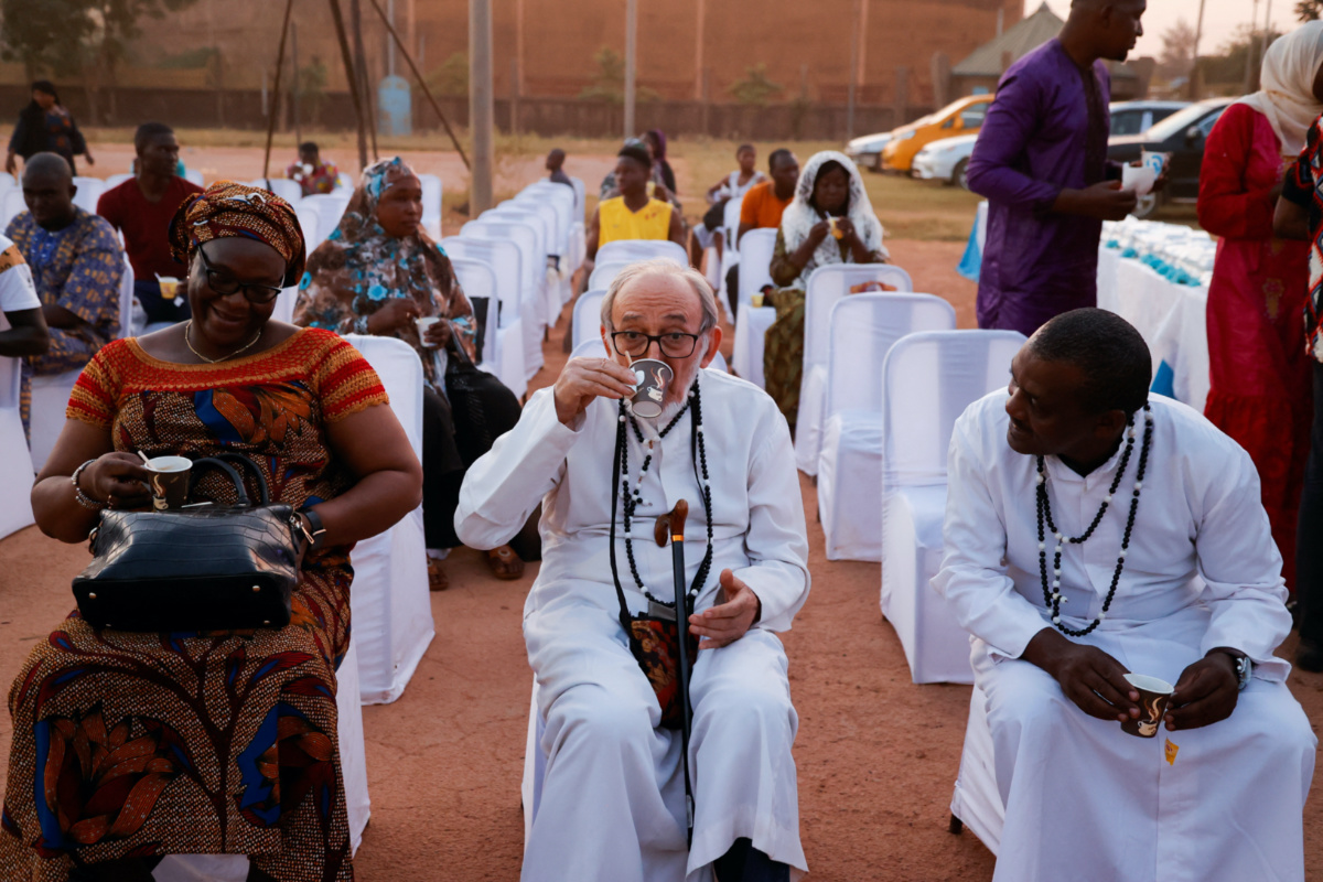 Dominic Appe, a catholic priest drinks coffee as Burkinabe Muslims and Christians gather to break the fast together in hopes of promoting religious tolerance during the Ramadan in Ouagadougou’s public square, Burkina Faso, on 31st March, 2023