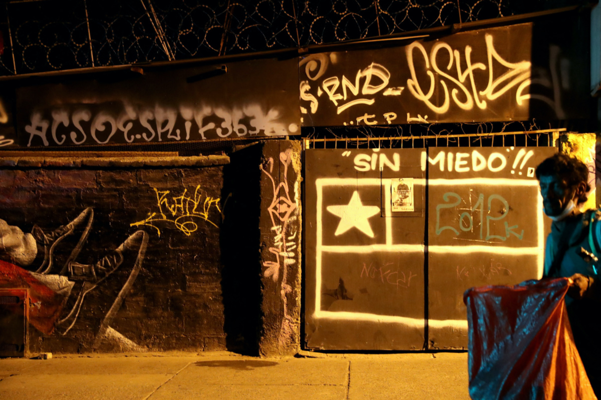A man walks past a graffiti reading 'Without Fear' on the outskirts of Santiago, Chile, on 6th March, 2021.