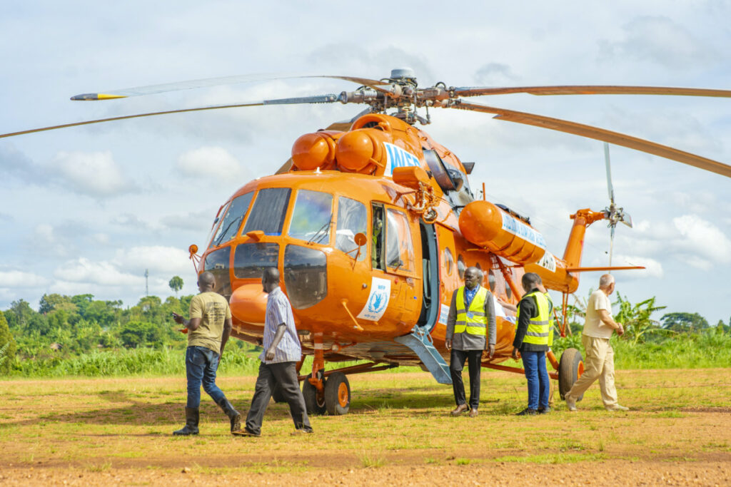 Humanitarian workers disembark from a United Nations Humanitarian Air Service helicopter managed by the World Food Programme, painted in orange colour as part of efforts to improve safety of operations in the restive eastern Congo at the Mahagi airstrip in Ituri province of the Democratic Republic of Congo in this photograph released on on 20th April, 2023.