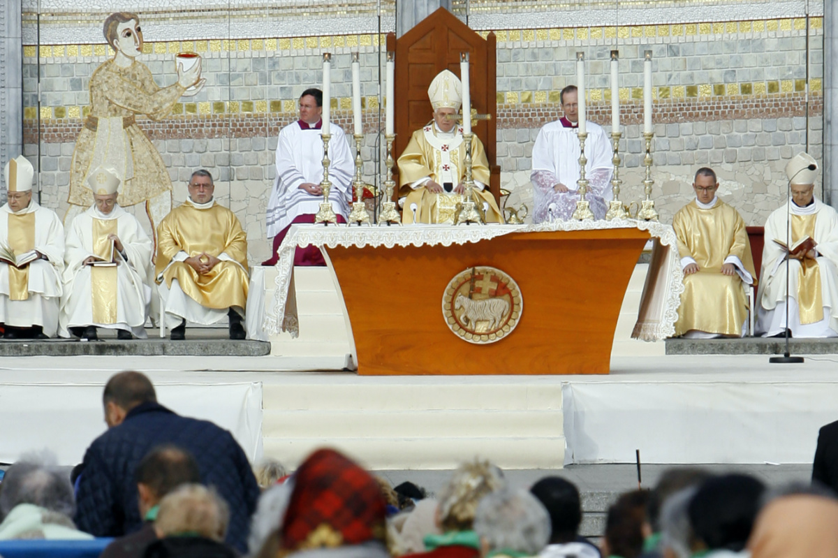 FILE - Pope Benedict XVI, center, celebrates a Mass in front of the Basilica of the Rosary in Lourdes, southwestern France, on Sept. 15, 2008. Behind him is one of the mosaics by Rev. Marko Ivan Rupnik, who was declared excommunicated in 2020 for committing one of the worst crimes in church law – using the confessional to absolve a woman with whom he had engaged in sexual activity. Officials at the Catholic shrine in Lourdes, France announced the creation of a study group Friday, March 31, 2023, to decide what to do with the sanctuary’s mosaics, its most famous but now controversial attraction. (AP Photo/Alessandra Tarant