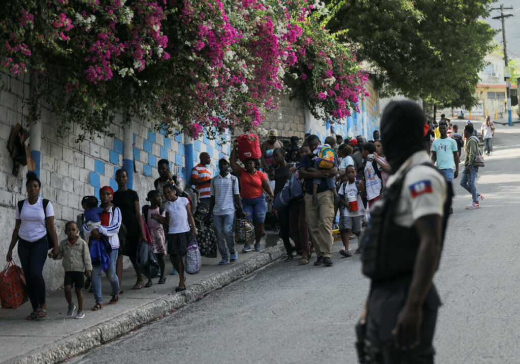 People carry their belongings while fleeing their homes and neighbourhood due to clashes between gangs, in Port-au-Prince, Haiti, on 24th April, 2023