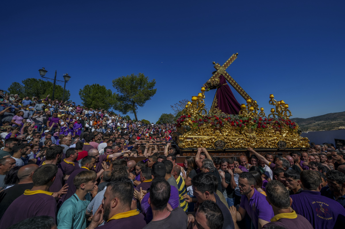 Penitents of the "Padre Jesus Nazareno" brotherhood carry a portable dais platform which supports a statue of Jesus Christ carried by "costaleros"during the holy week procession in Priego de Cordoba, southern Spain, Friday, 7th April, 2023. 
