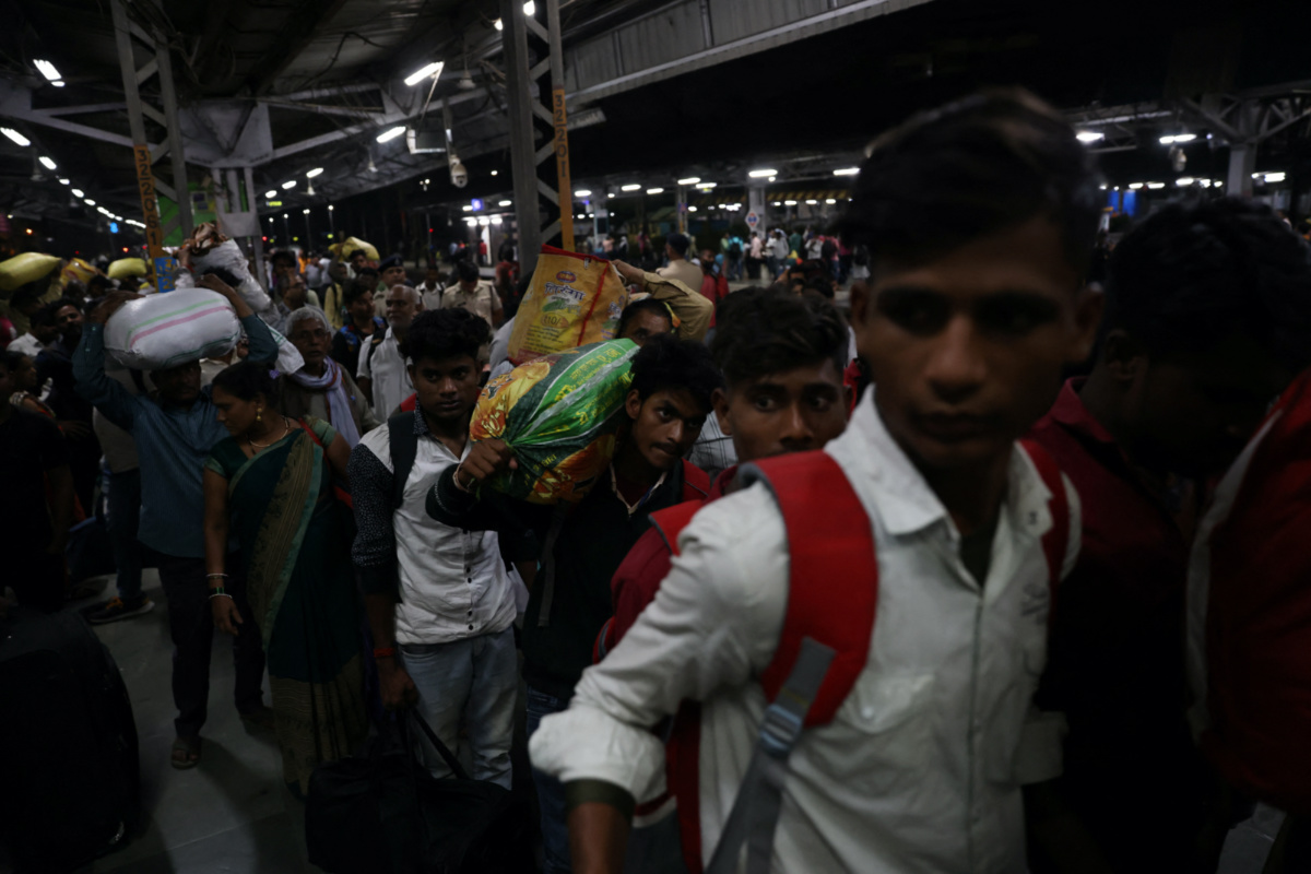 A 21-year-old aspiring college student and migrant worker Sujeet Kumar carries his luggage as he exits Thane railway station on the outskirts of, Mumbai, India, on 11th March, 2023. 