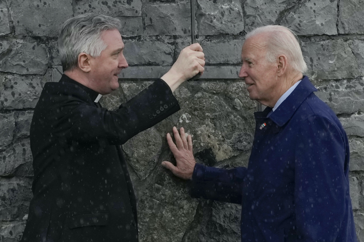 President Joe Biden touches part of the original stonework from the apparition gable at the Knock Shrine as he talks with Father Richard Gibbons, parish priest and rector of Knock Shrine, in Knock, Ireland, on Friday, 14th April, 2023.