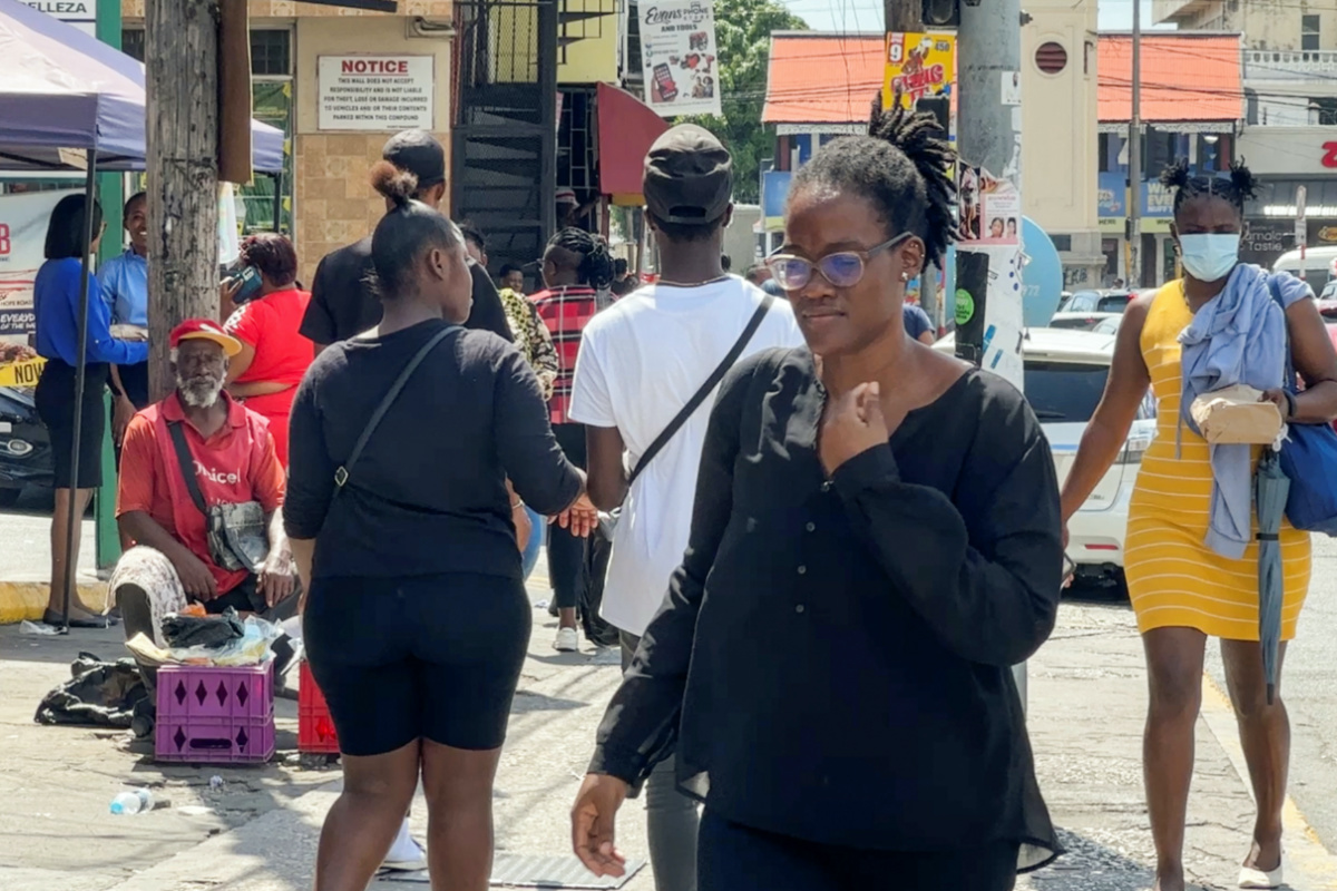 People walk on a street at the Half Way Tree neighborhood in Kingston, Jamaica, on 22nd March, 2023.