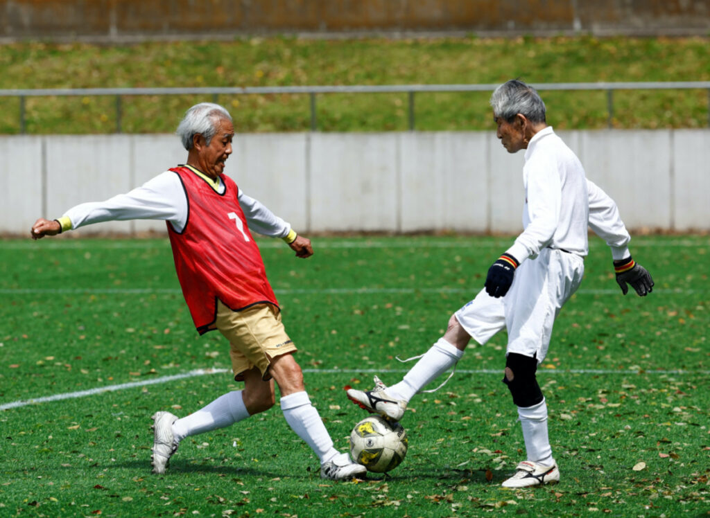 Red Star’s midfielder Mutsuhiko Nomura, 83, shoots to score a goal against Blue Hawai’s goalkeeper Hiroshi Nishino, 87, at the SFL 80 League opening match in Tokyo, Japan, on 12th April, 2023.