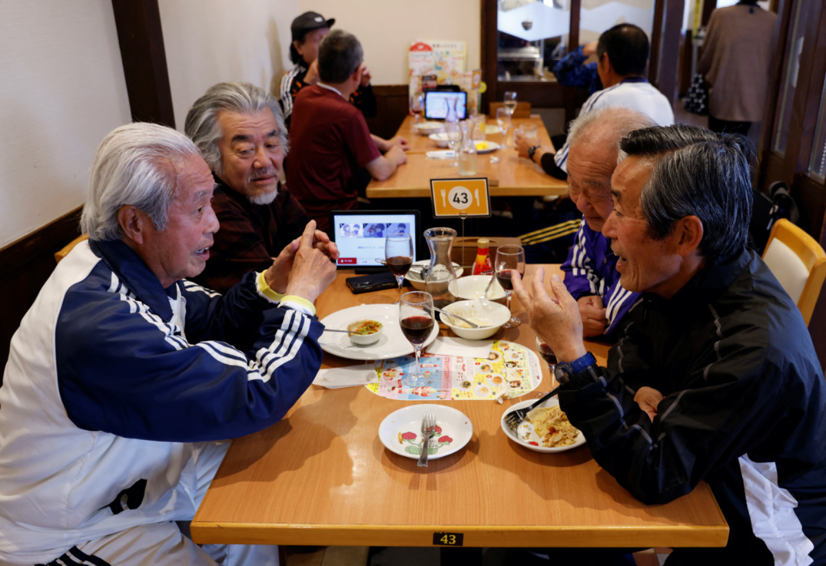 Mutsuhiko Nomura 83, chats with his TAFF teammates, a football team where the players’ average age is 65-year-old, at a restaurant after their practice in Tokyo, Japan, on 31st March 2023