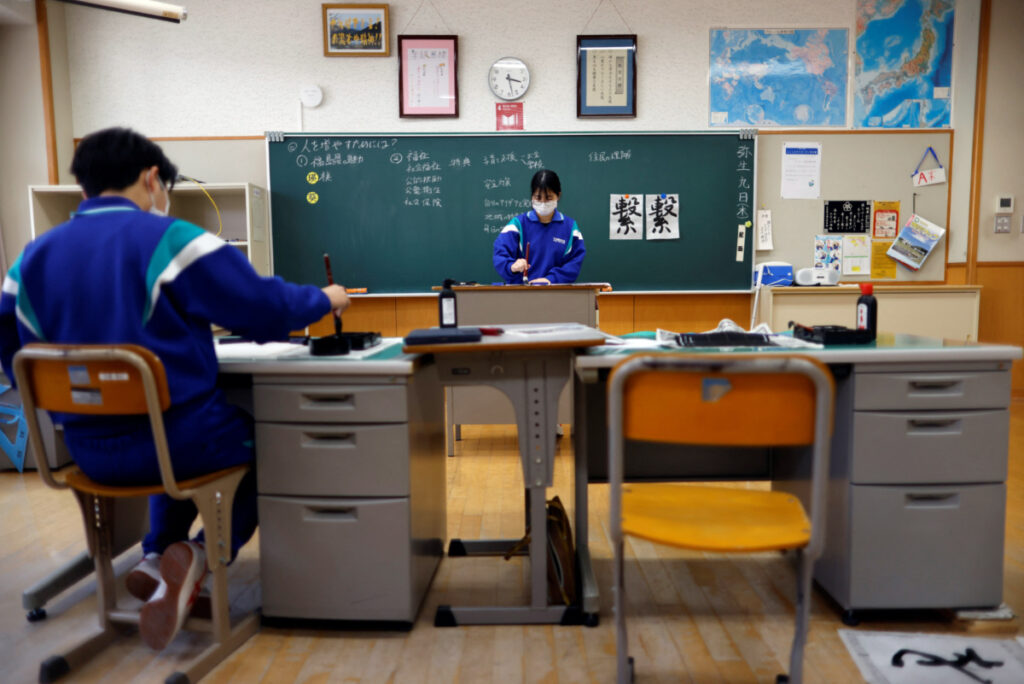 Eita Sato, 15, and Aoi Hoshi, 15, who are the only two students at Yumoto Junior High School, attend a Japanese traditional calligraphy class to write a message that will be engraved into the school's closing memorial stone, a few days before their graduation and the institution's closing ceremony, in Ten-ei Village, Fukushima Prefecture, Japan, on 9th March, 2023